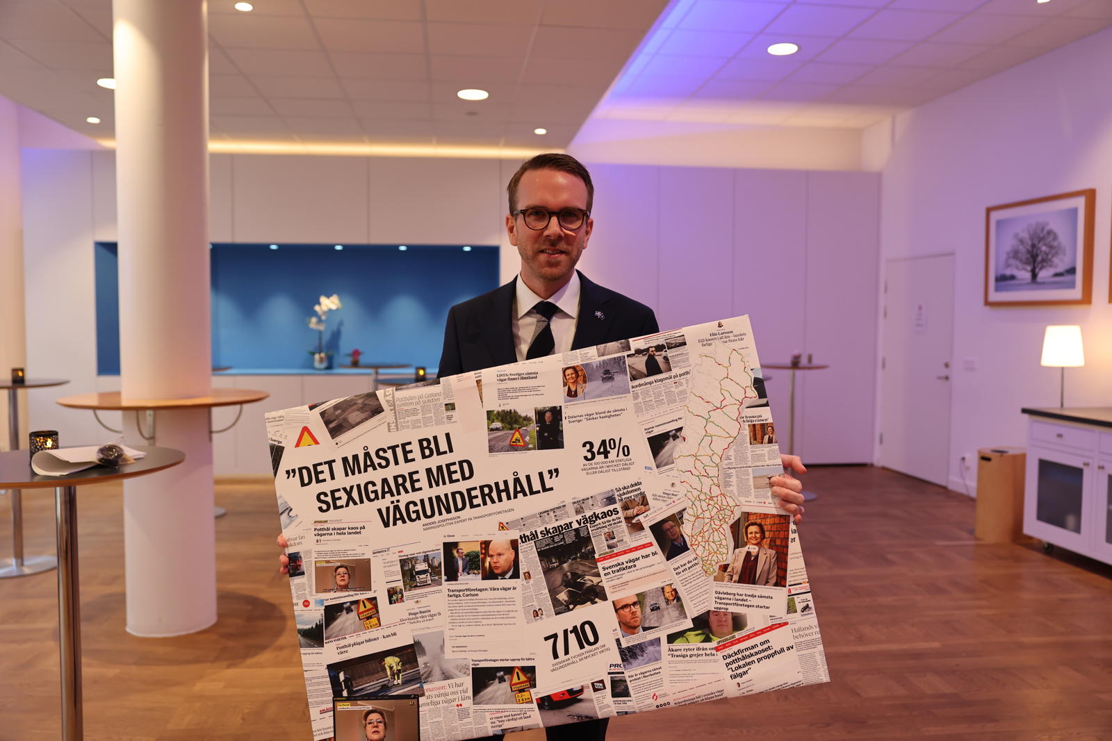 Infrastrukturminister Andreas Carlson fick en canvastavla av Transportföretagen för att påminna honom om att kampen för bättre vägunderhåll går vidare.